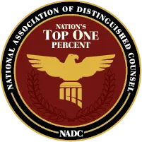 An elegant circular badge or logo for the National Association of Distinguished Counsel (NADC).