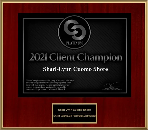 A formal framed award plaque with a dark center plate reading 2021 Client Champion Platinum presented to Shari-Lynn Cuomo Shore by Martindale-Hubbell