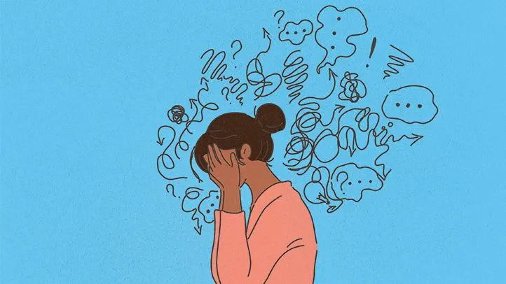 An illustration of a person with dark hair tied in a bun, covering their face with their hands against a solid blue background, surrounded by a chaotic cloud of tangled scribbles, arrows, question marks, and thought bubbles symbolizing overwhelming thoughts, anxiety, or stress.