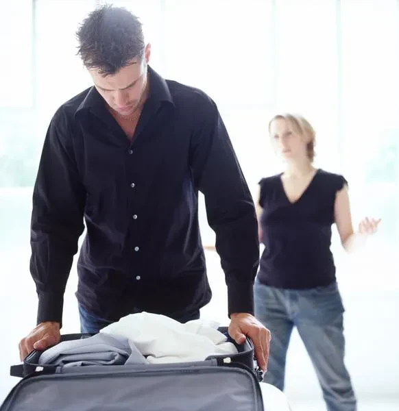 A man being kicked out of a home by his spouse