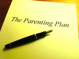 A paper that reads "The Parenting Plan" with a line through it.