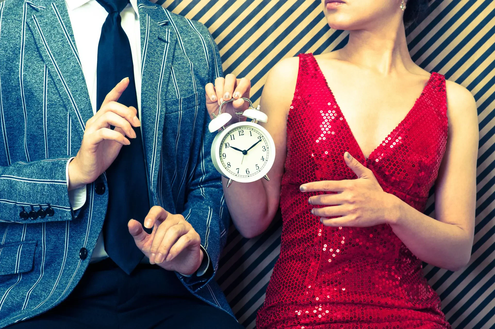 A man and a woman. The woman is holding a clock