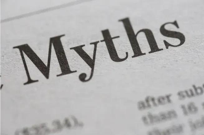 Close-up of the word Myths printed in large, bold black letters on a newspaper or magazine page, with smaller, blurred text visible around it.