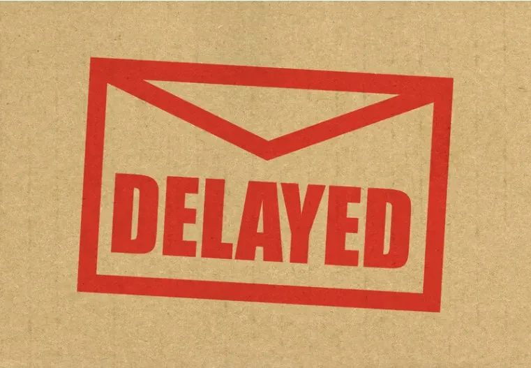 A red envelope outline with the word DELAYED inside is printed on a brown cardboard background.