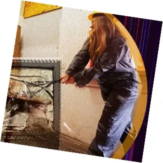 A woman wearing a hard hat holds a hammer, ready to work on a construction project.