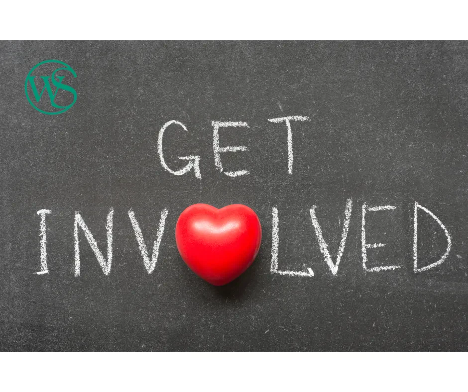 A three-dimensional red heart toy replaces the letter "O" in the word "INVOLVED". In the top left corner, there is a small teal circular logo.