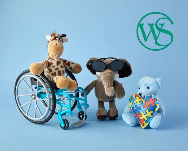 A plush toy in a wheelchair, flanked by a teddy bear and a giraffe, symbolizing support and companionship.