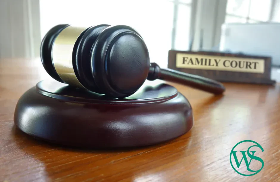 A Judge's Anvil Resting on a Wooden Tabletop and in the background a plaque with the words "FAMILY COURT" carved into it.