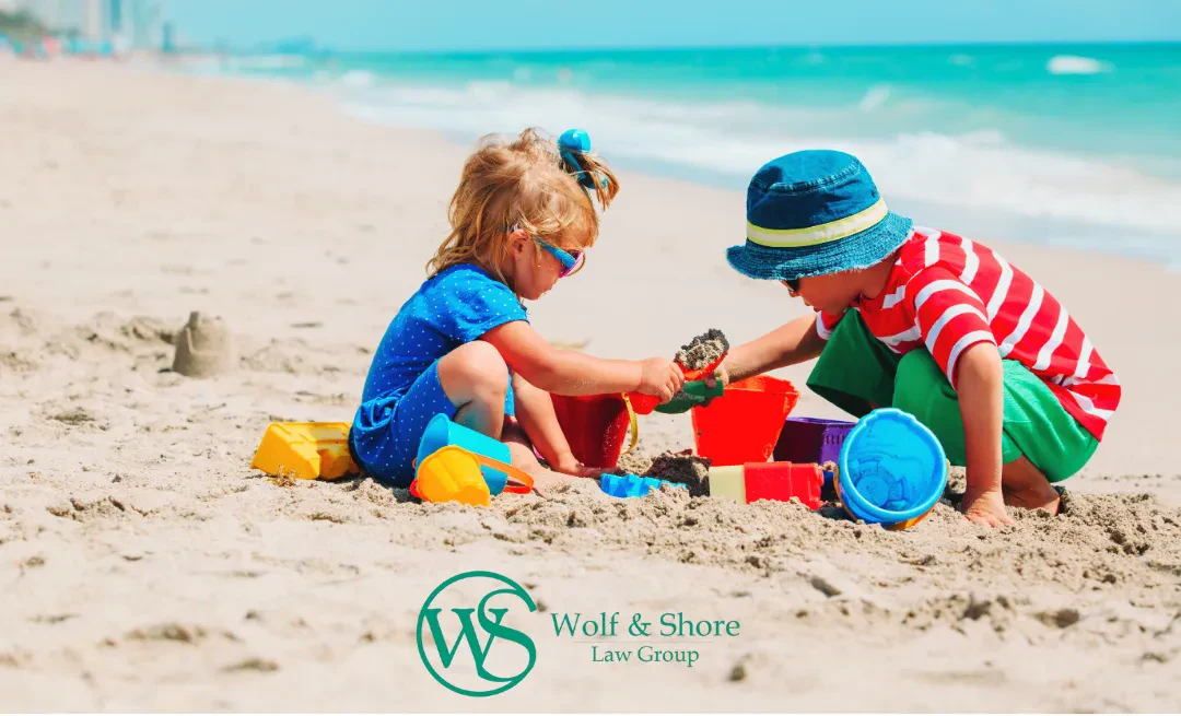 Two children joyfully playing in the sand on a sunny beach, building sandcastles and enjoying their time together.