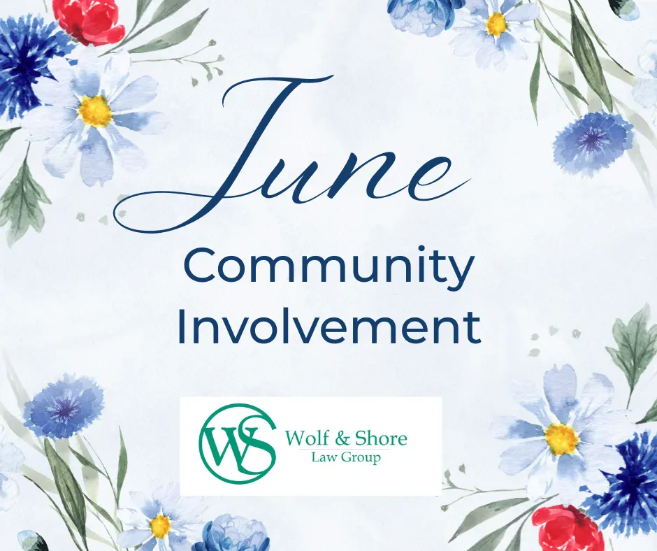 Floral border with text: June Community Involvement. Wolf & Shore Law Group logo is at the bottom center. Light blue watercolor background with blue, red, and yellow flowers.